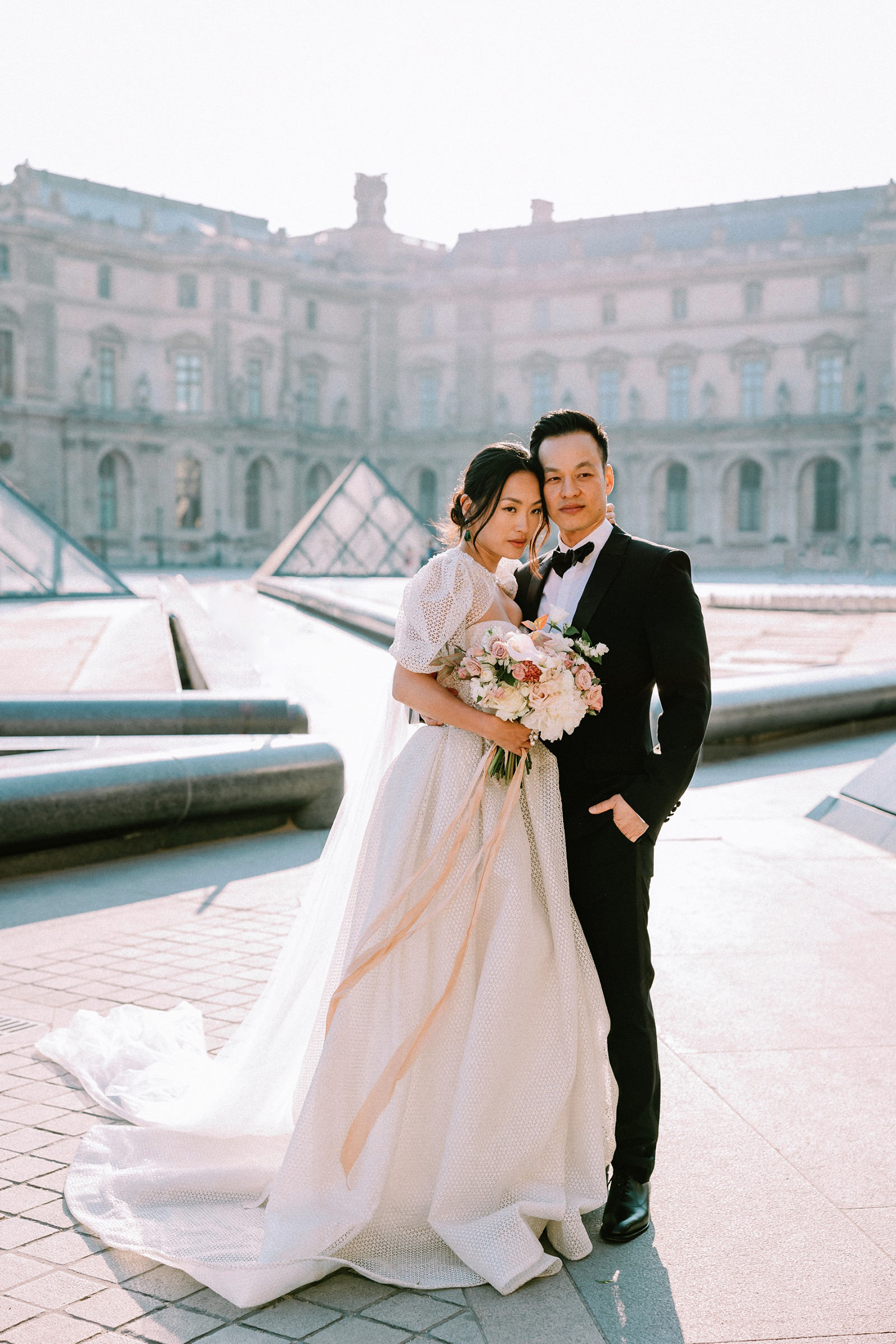Couple posing in front of Louvre for Paris PreWedding Photographer